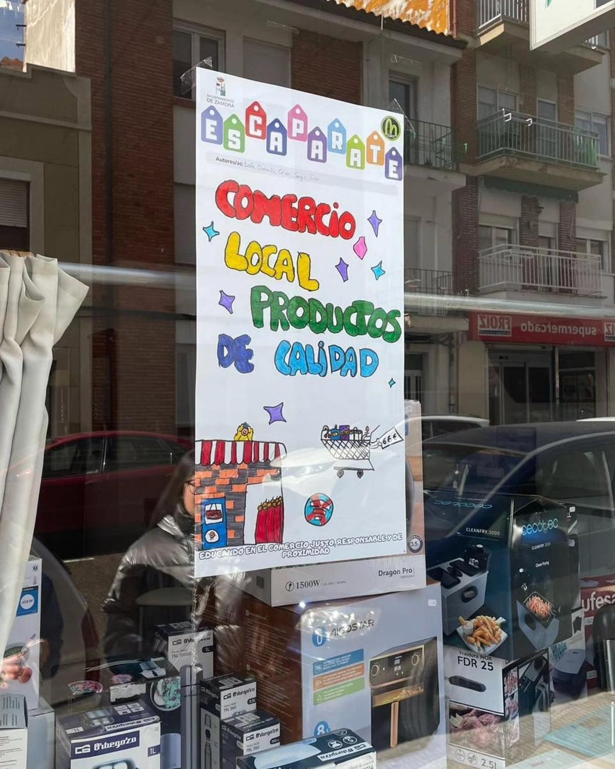 Escaparate de un comercio con uno de los carteles del proyecto