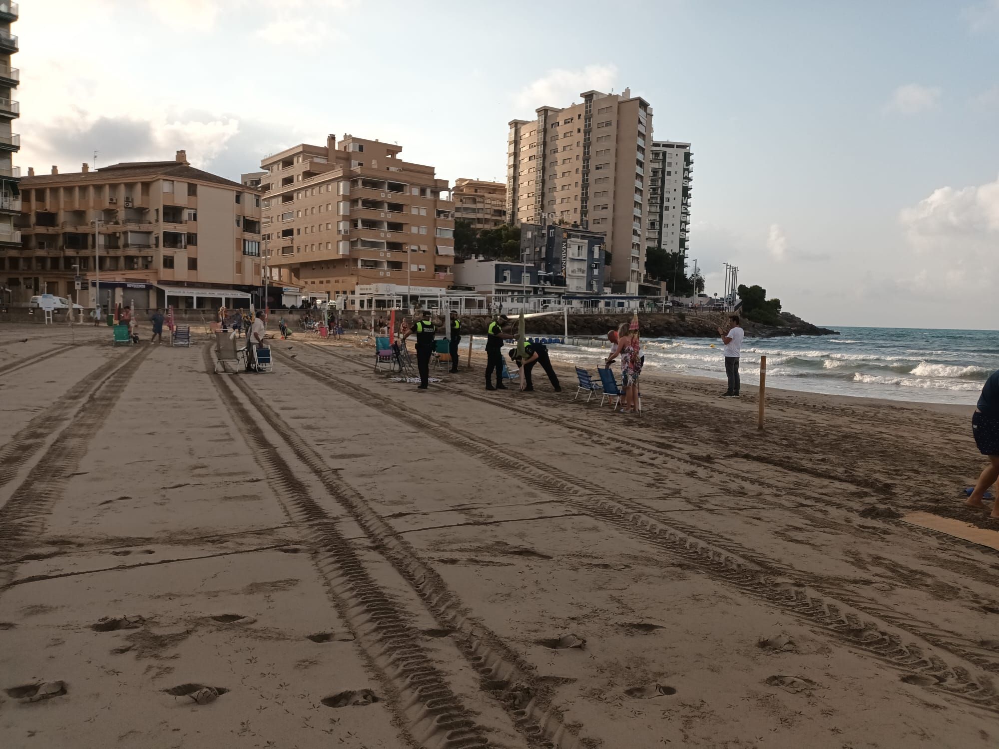 La recogida de enseres en la playa de Orpesa tras el incumplimiento de la ordenanza municipal al reservar los sitios en la primera línea.