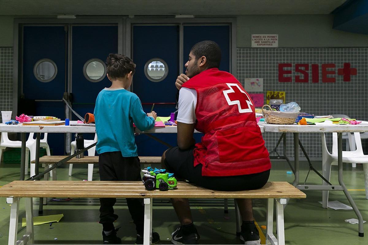 Un voluntario con un menor en el pabellón del Vedat