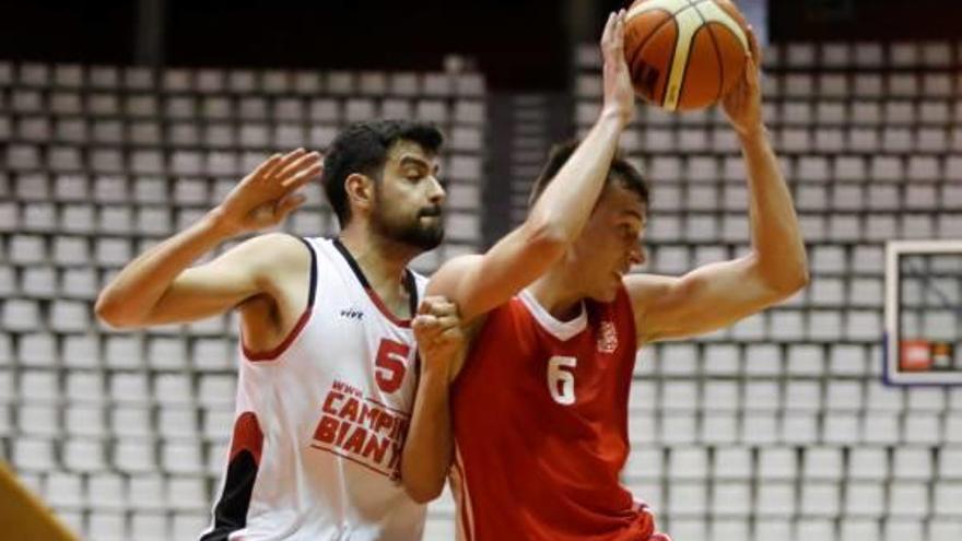 Pau Juscafresa intenta aguantar la pilota davant la pressió d&#039;un jugador del Roser.