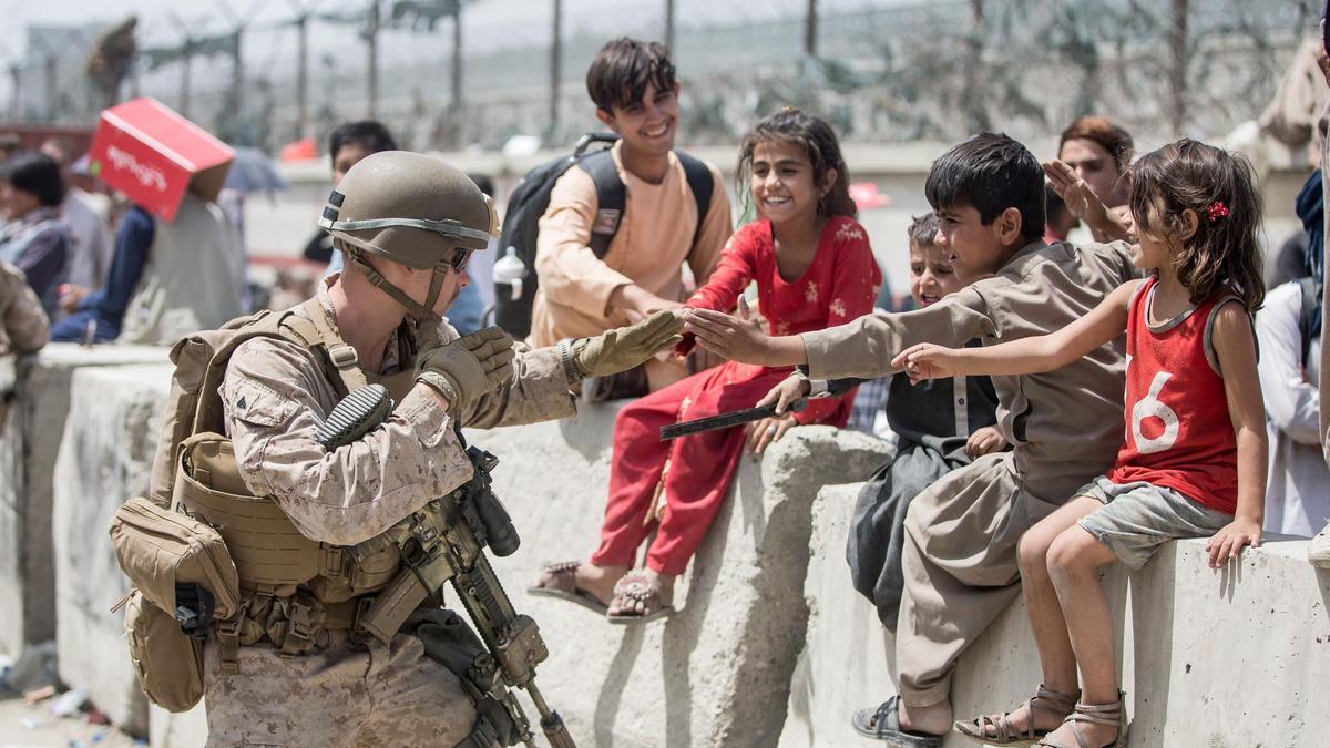 Un soldado estadounidense juega con varios niños en Kabul.