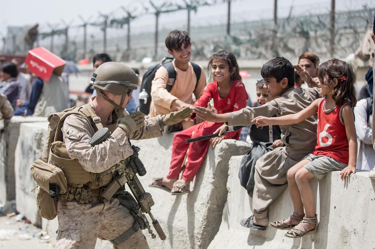 Un soldado estadounidense juega con un niño en Kabul.