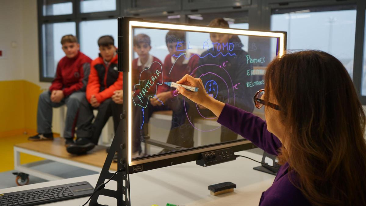 Una profesora usa una pizarra transparente que Trébol ha implementado en centros educativos, con pautas metodológicas para mejorar la gestión de la atención. Con estas pizarras, los docentes no le dan la espalda a sus alumnos y ello favorece la comunicación y reduce las distracciones.