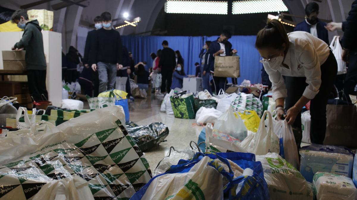 Estudiantes y personal del centro organizan las bolsas y cajas de material que se han recogido para enviar a Ucrania.