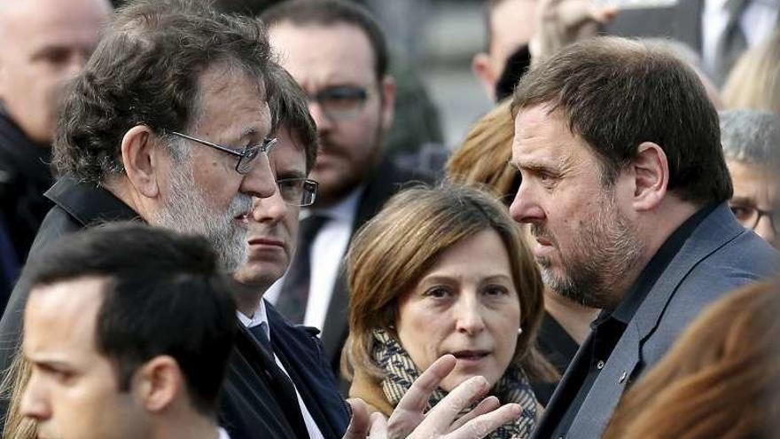 Rajoy, hablando con Junqueras y Puigdemont. // Reuters
