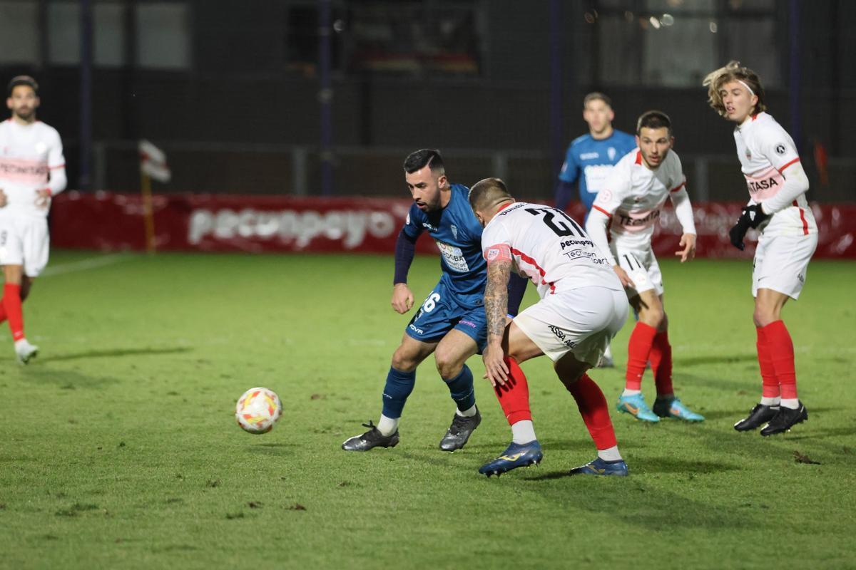 Carlos Puga trata de escapar de la vigilancia de un rival en el partido ante el Sanse.