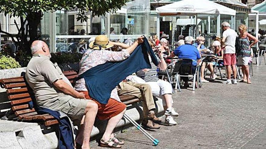 Turistas al sol en una zona de terrazas en A Coruña.