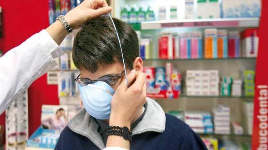 Un joven se prueba una mascarilla en la Farmacia Vigo.