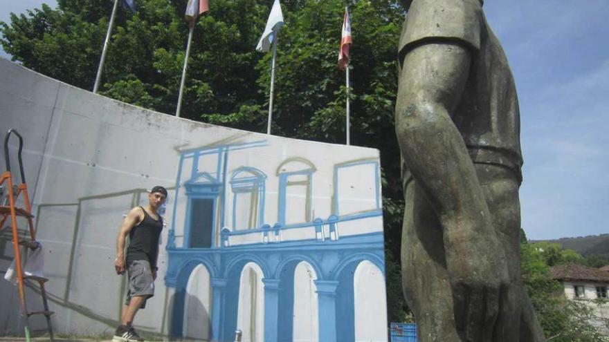 Allande pone color al muro que rodea la estatua de &quot;El emigrante&quot;