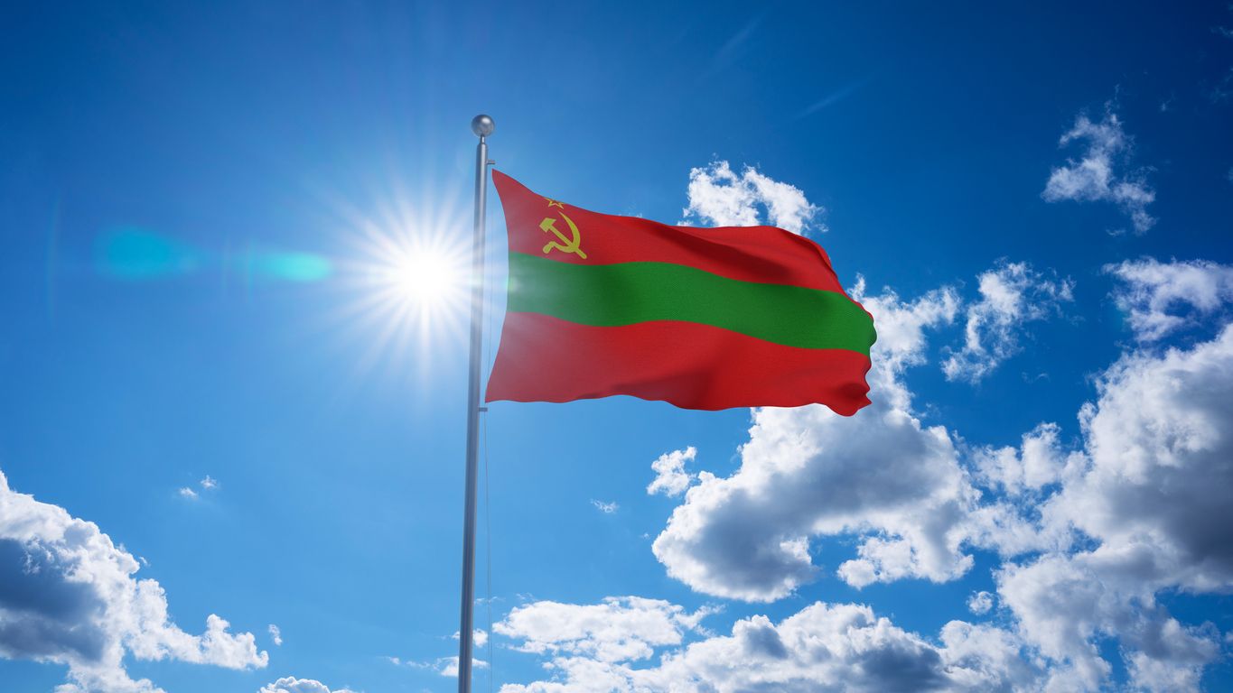 Bandera de Transnistria ondeando en el mástil, sol brillante en el cielo azul del verano en el fondo