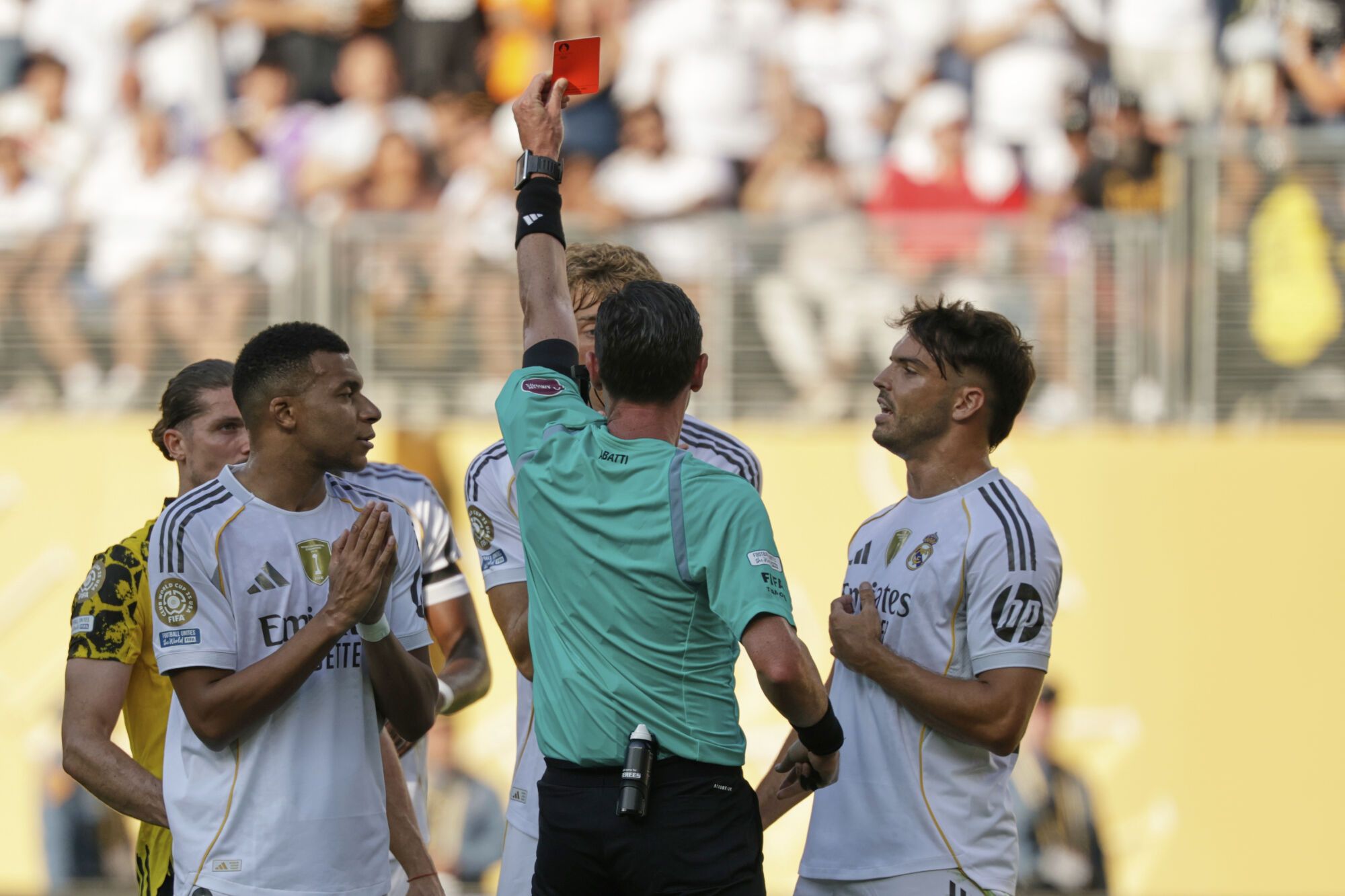Referee Ramon Abatti shows a red card to Real Madrid's Dean Huijsen during the Club World Cup quarterfinal soccer match between Real Madrid and Borussia Dortmund in East Rutherford, N.J., Saturday, July 5, 2025. (AP Photo/Adam Hunger)