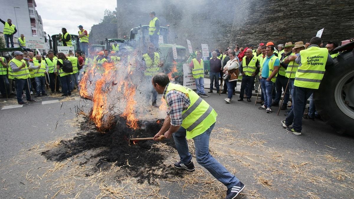 Un ganadero hace una hoguera en la manifestacion de ayer, ante la muralla de Lugo