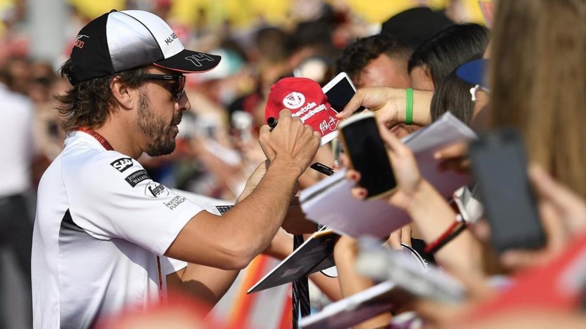 Fernando Alonso firma autógrafos en Hungaroring.