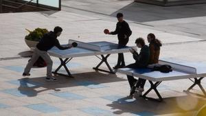 Alumnos universitarios, jungando a tenis de mesa en el campus.