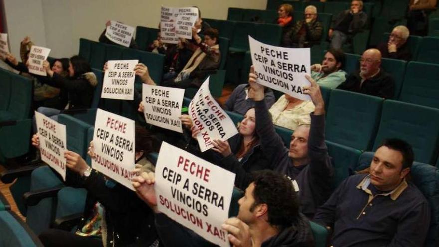 Padres de alumnos del colegio Serra de Vincios levantaron carteles durante el pleno. // José Lores