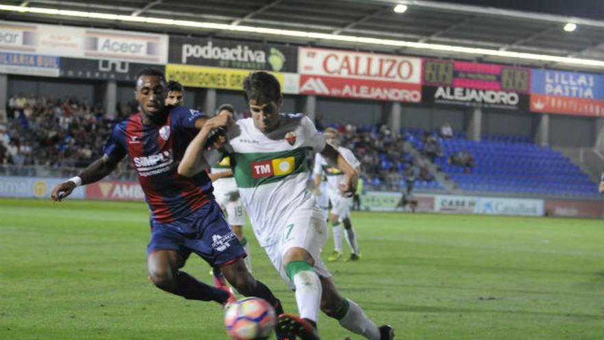 Dos jugadores disputan un balón en el partido en Huesca