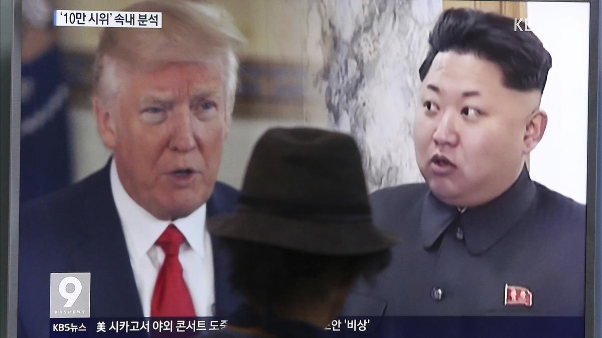 Un home mira la televisió en una estació de tren de Corea del Sud, on es veu a Donald Trump i Kim Jong Un.