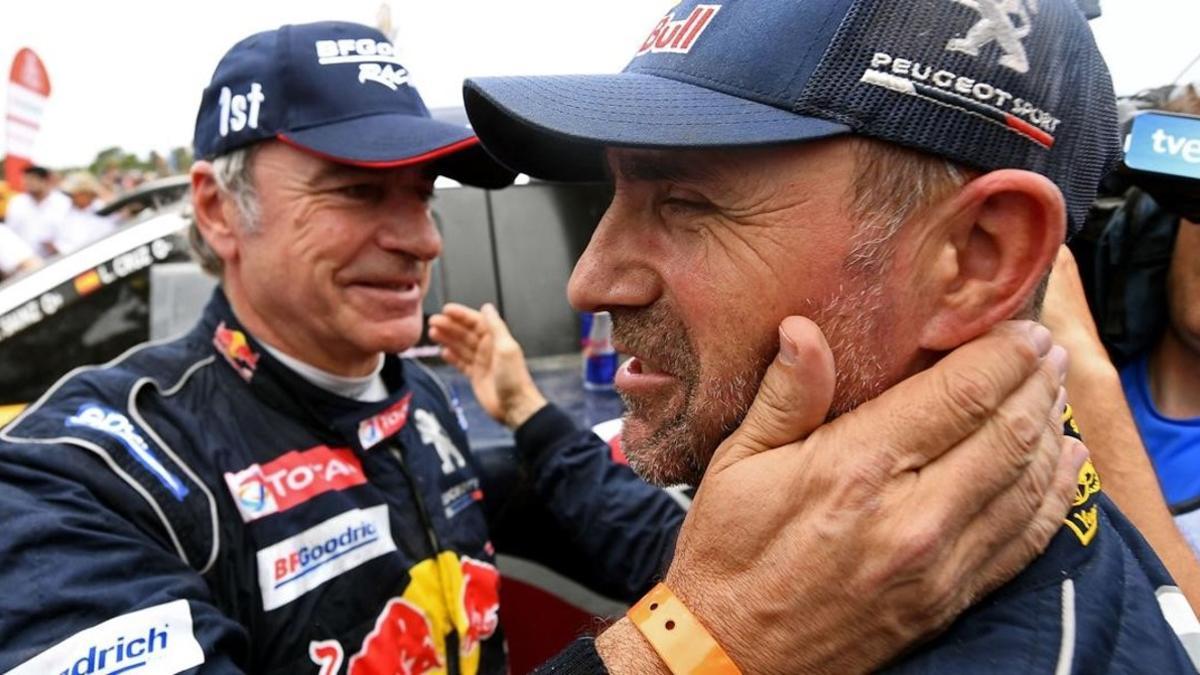 Stéphane Peterhansel, 'monsieur Dakar', ganador de 13 rallys Dakar, felicita a su amigo y compañero en Peugeot, Carlos Sainz.