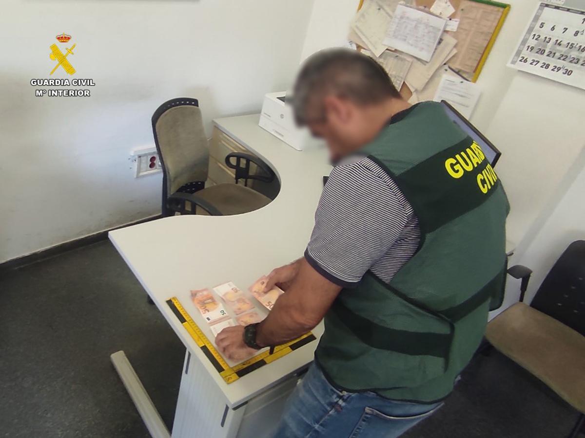 Un agente de la Guardia Civil muestra el dinero falso que ha sido incautado en Santa Pola