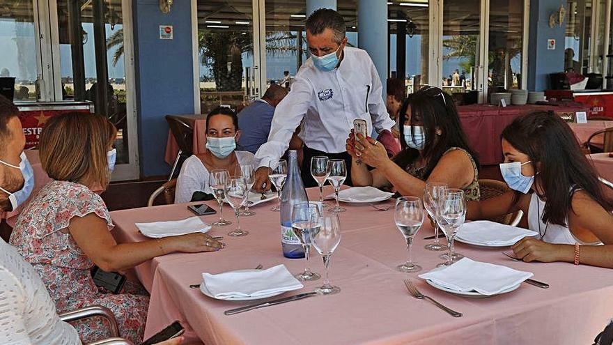 Los clientes de un restaurante de la Malva-rosa esperan a ser servidos con la mascarilla puesta, tal como es obligatorio desde ayer.