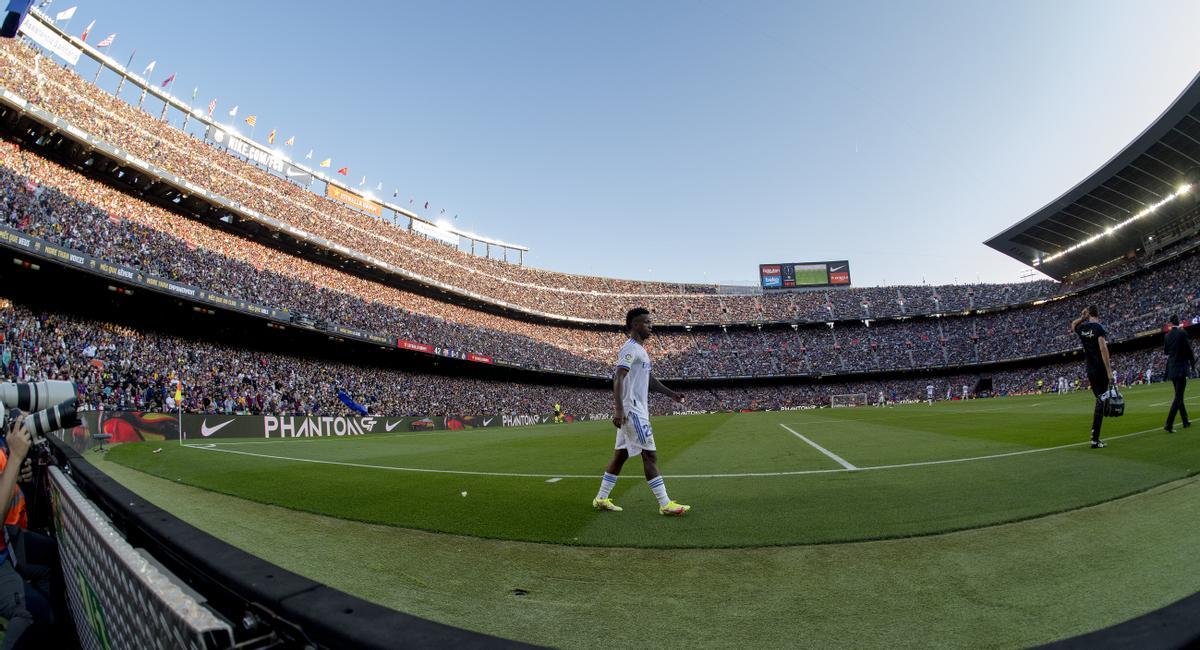 Vinicius camina fuera del terreno de juego tras ser sustituído, ante un Camp Nou lleno de público