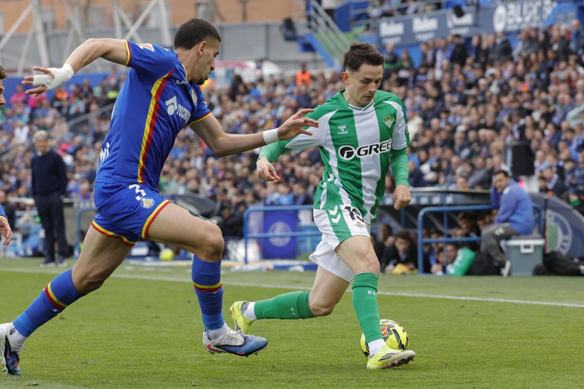 El centrocampista del Betis Álvaro Fidalgo (d) pelea un balón con el defensa marroquí del Getafe Abdel Abqar.