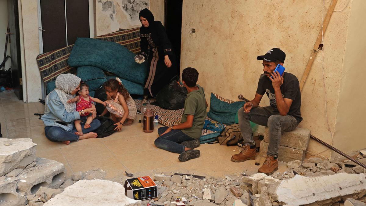 Wissam Joudeh (derecha) junto a su familia en su casa parcialmente destruida, en Rafah.