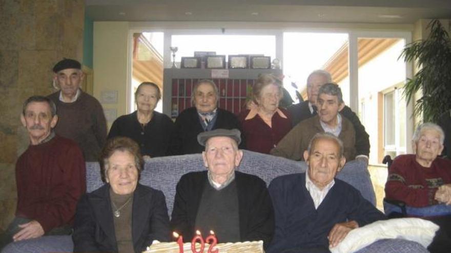 Isidoro del Buey, en el centro, rodeado de familiares y amigos con la tarta de su 102 cumpleaños.