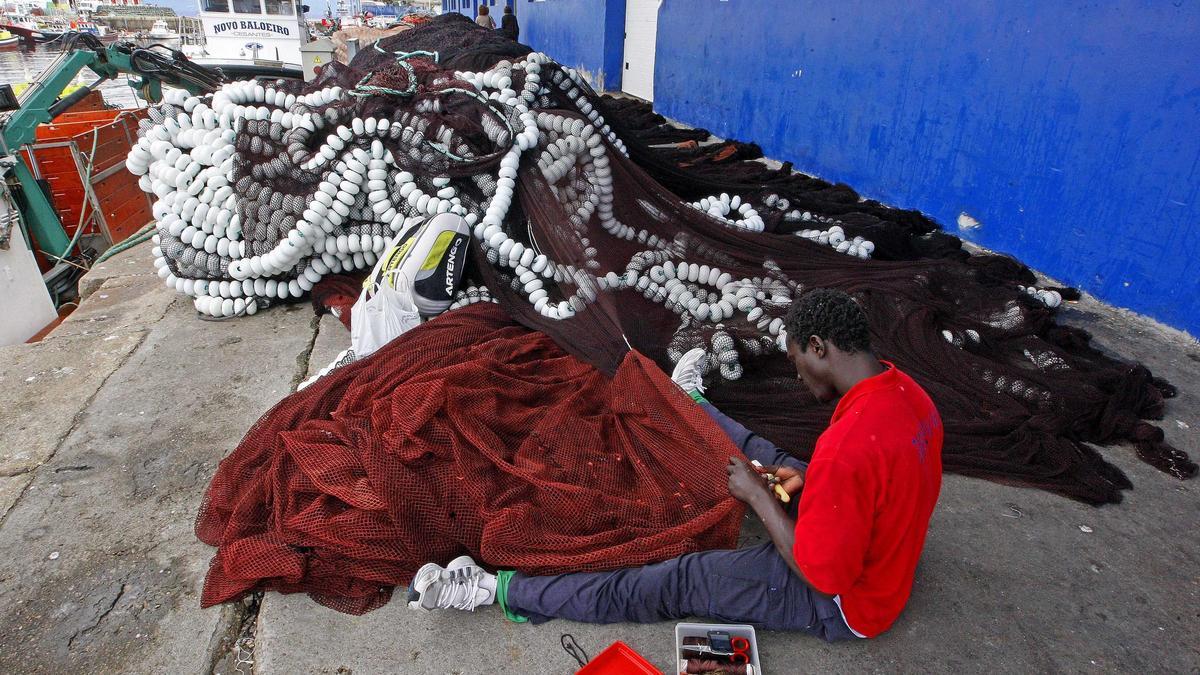 Un marinero trabajando en las redes de un barco.