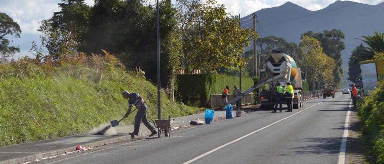 Operarios trabajando en la nueva acera entre La Isla y La Espasa.