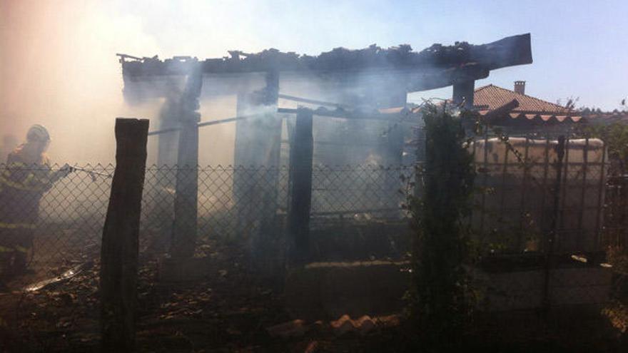 Los bomberos apagan el incendio en el alpendre. // FdV