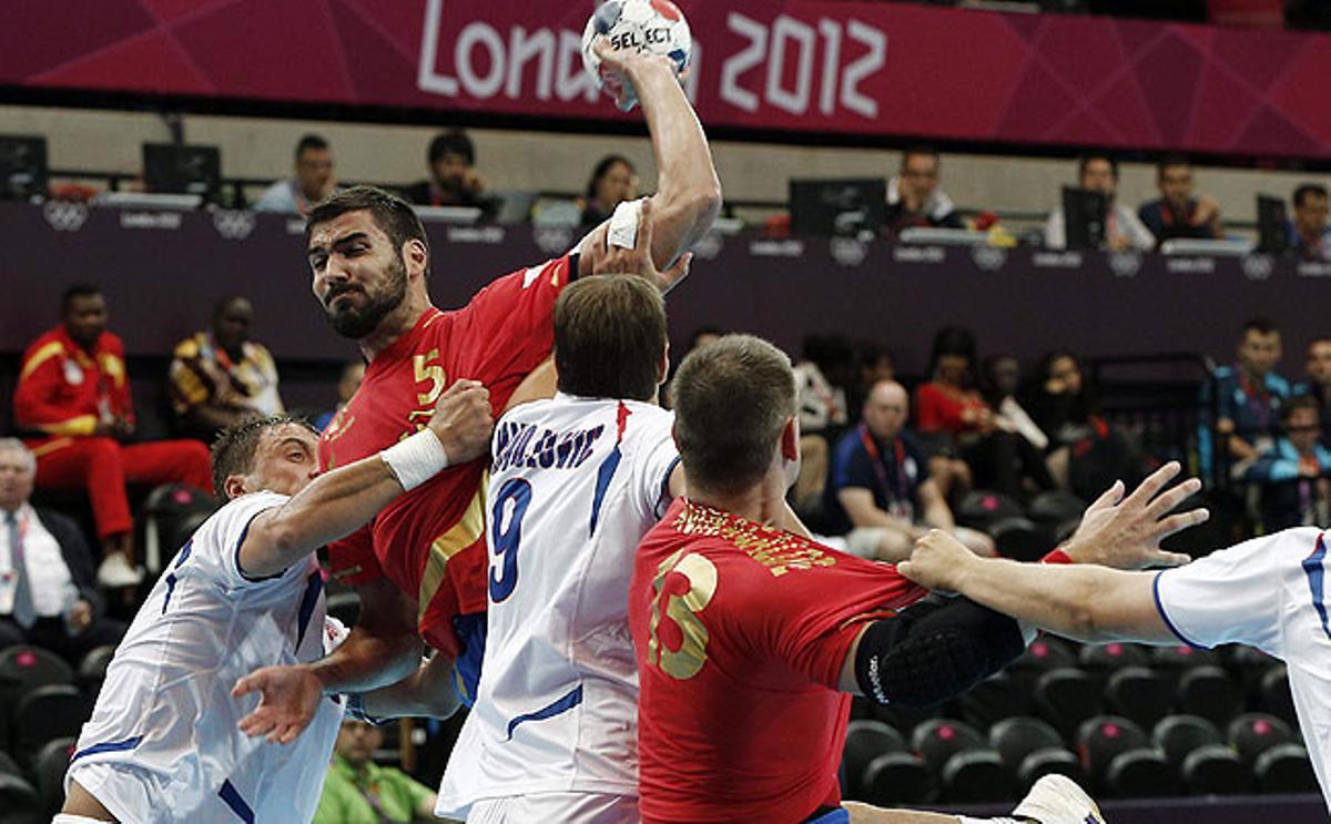 El jugador de la selecció espanyola d’handbol, Jorge Maqueda, llança a porta davant l’oposició dels serbis Ilic Momir i Nikola Majnolovic durant el partit en què Espanya ha obtingut la victòria per 26-21.