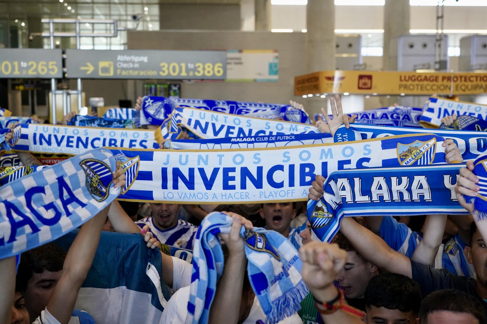 La afición del Málaga CF toma el aeropuerto para despedir al equipo antes de la final por el ascenso a Segunda en Tarragona