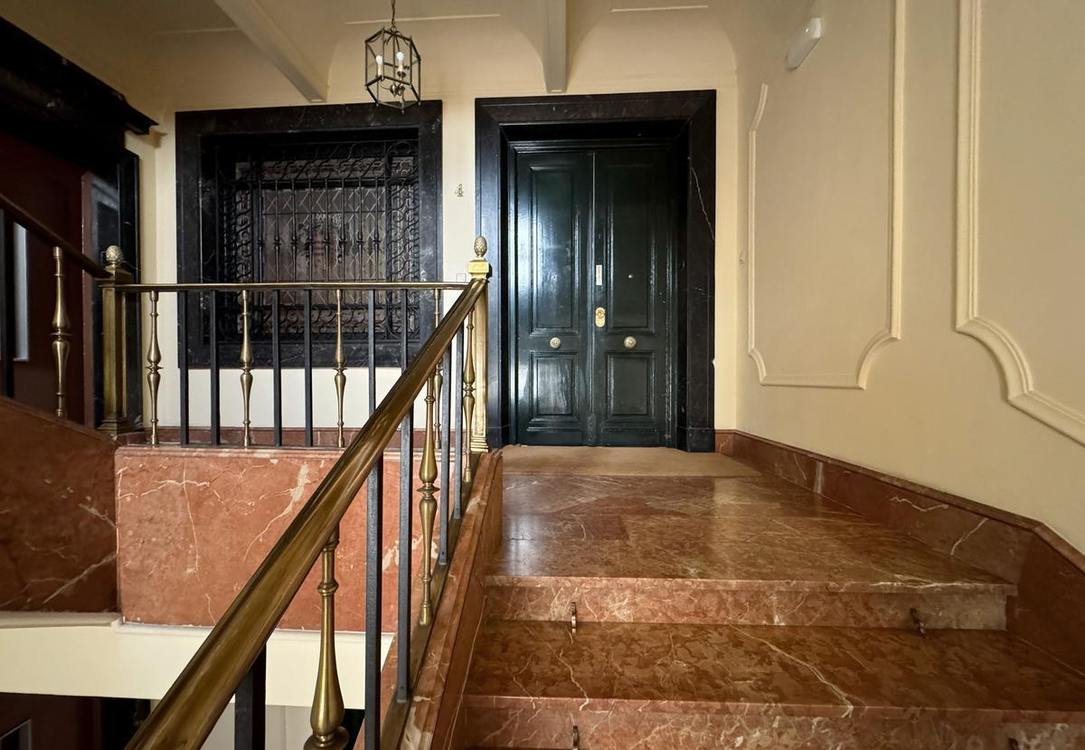 Entrada al piso de la calle Madrazo de Madrid que la Administración mantiene si uso.