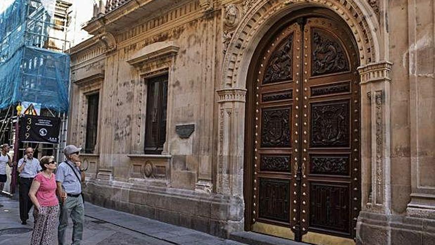 Dos personas observan la puerta de entrada a la antigua Diputación Provincial.