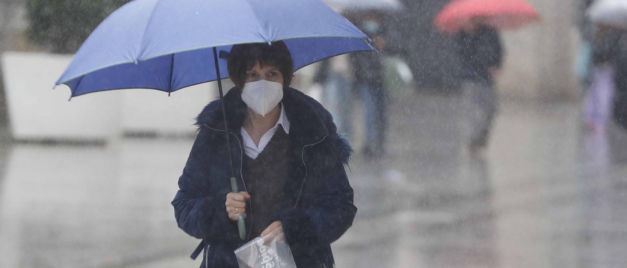 Una mujer se protege de la lluvia con un paraguas en Príncipe