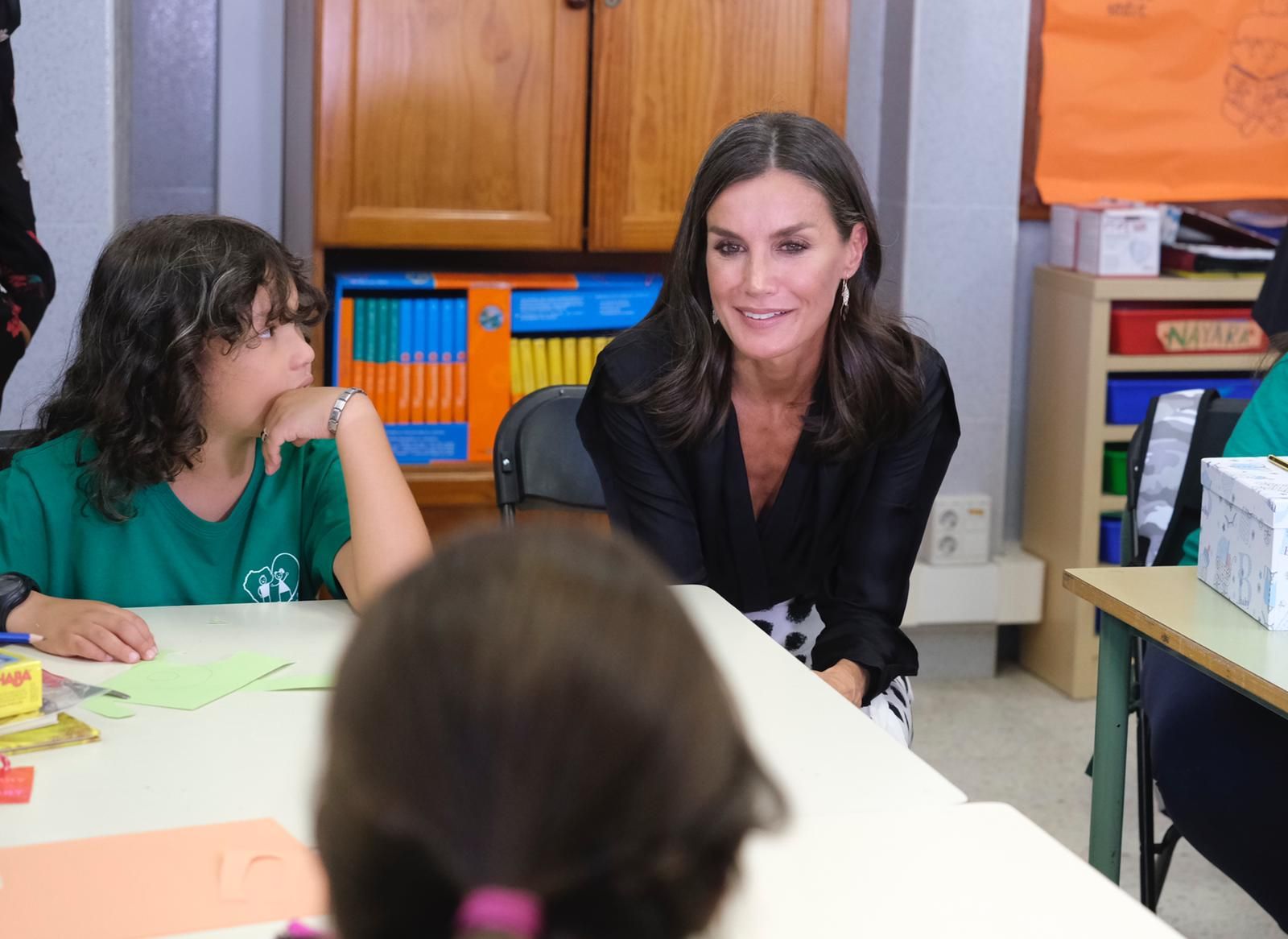 Doña Letizia habla con varios alumnos del centro escolar.