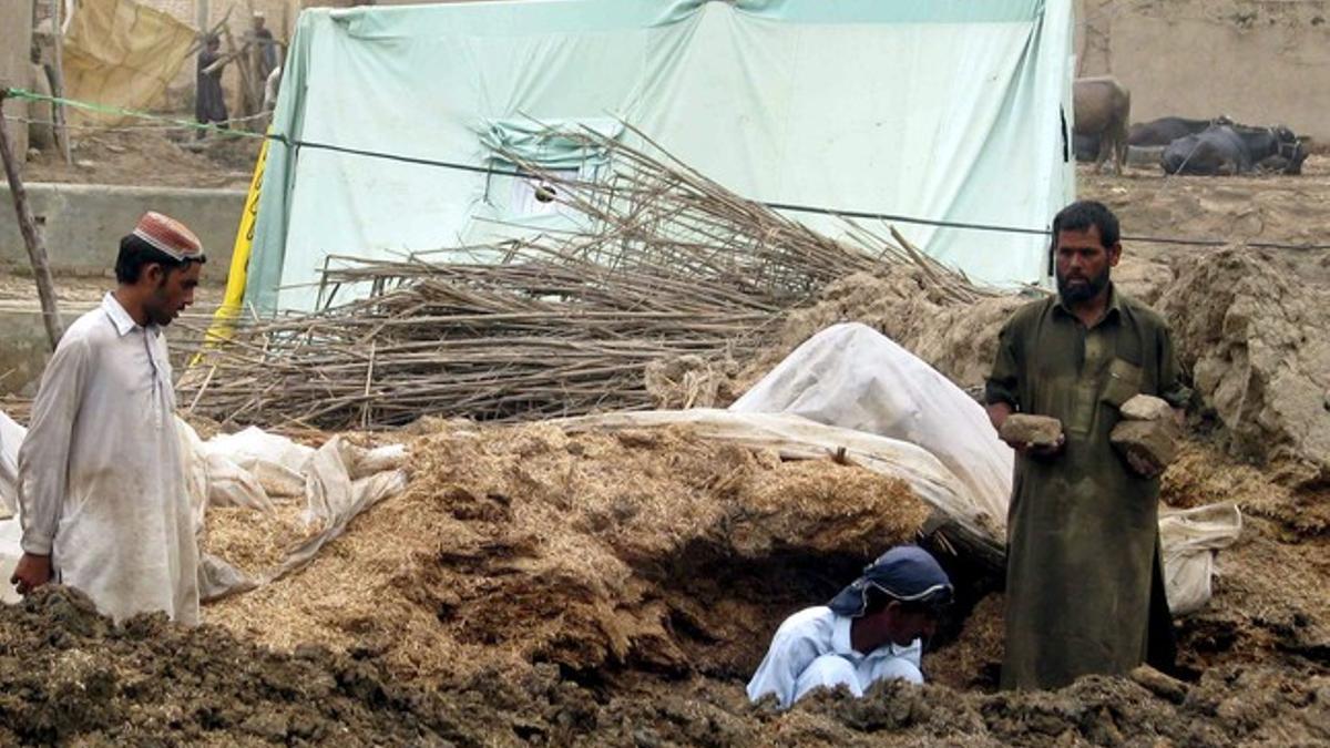 Afectados por las inundaciones buscan entre los escombros de su casa con la esperanza de encontrar alguna pertenencia.