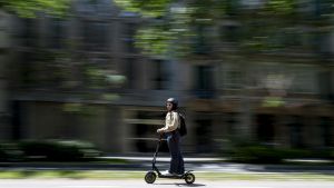 Una persona en patinete eléctrico circulando por una calle de Barcelona.