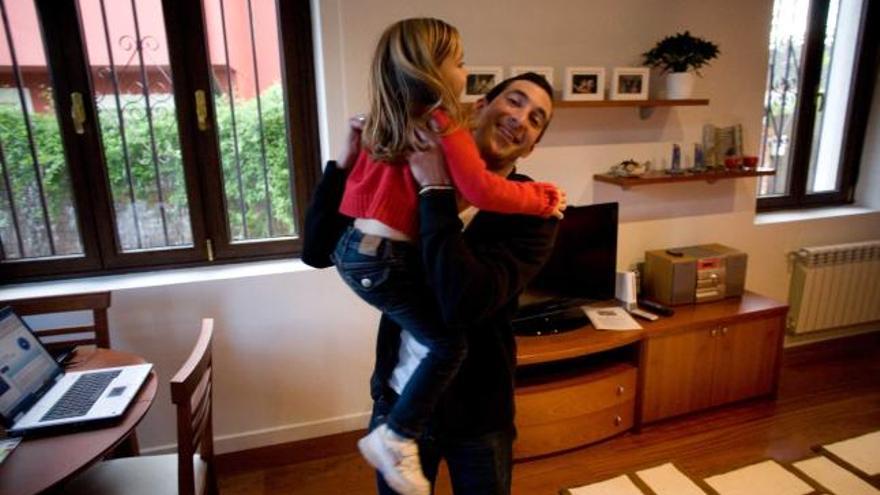 Anthony Hecth con su hija Ilana en brazos, en su domicilio de Salinas (Castrillón).