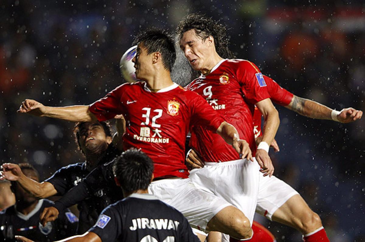Els jugadors de l’equip Guangzhou Evergrande, Sun Xiang (centre) i Cleverson Gabriel Cordova (dreta), durant un partit contra el Buriram United de la Lliga de Campions asiàtica, disputat a Buriram (Tailàndia).
