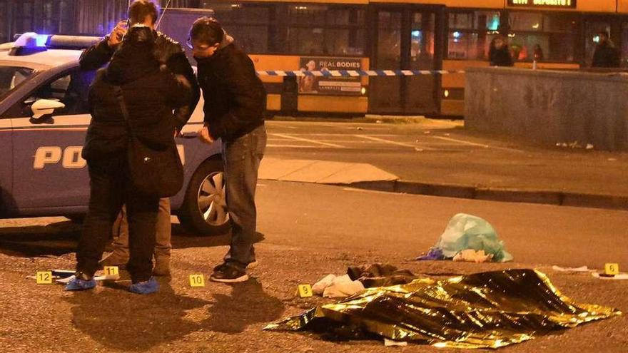 El cadáver de Amri, en la calle de Milán donde fue abatido, con los investigadores recopilando pruebas. // Reuters