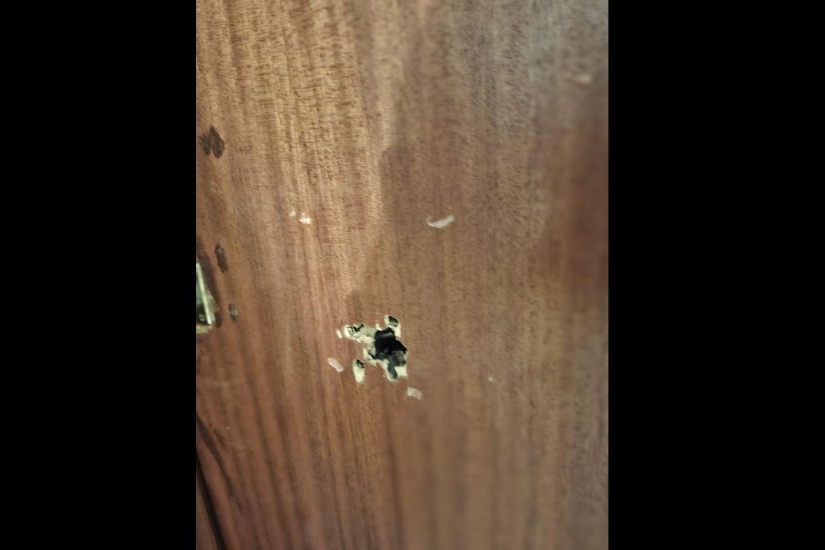 Boquete dejado por el disparo de escopeta en la puerta de una vivienda de La Coma, en Paterna.