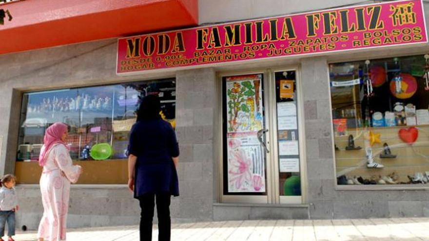 Dos mujeres y una niña ante el comercio de la familia cerrado tras el fallecimiento del bebé. i SANTI BLANCO