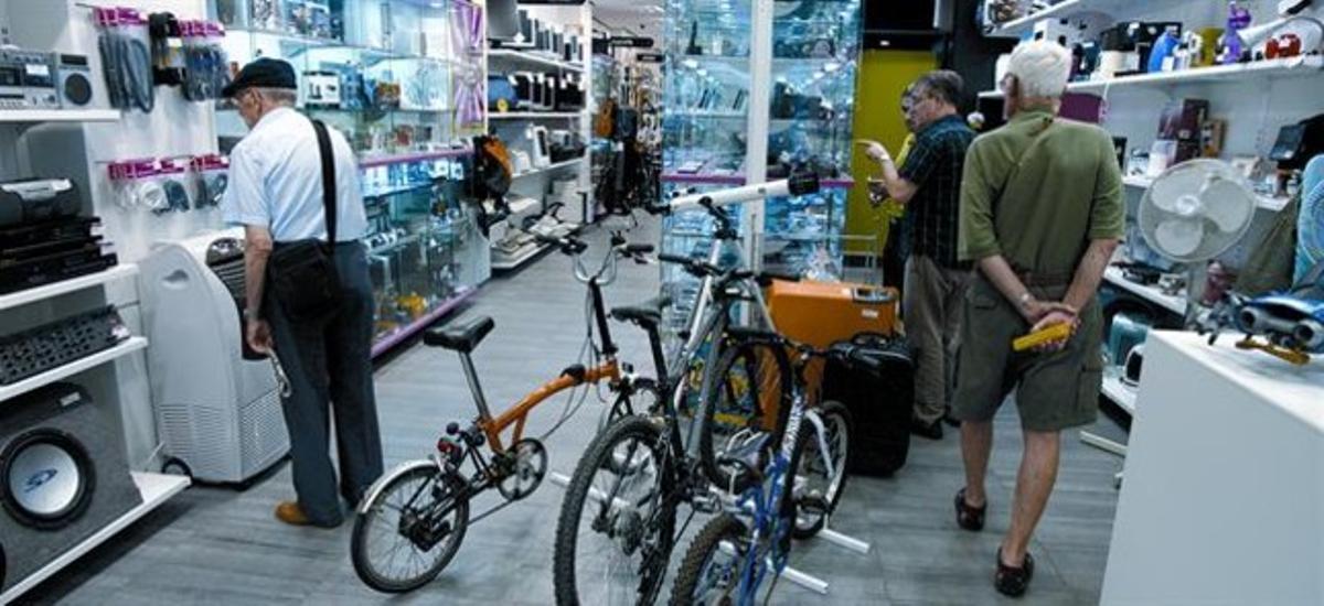 Diversos clients en una botiga de Cash Converters de Barcelona. Diversos clients en una botiga de Cash Converters de Barcelona.