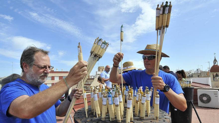 Los trabajadores de la Pirotecnia Ferrández ultiman el montaje de palmeras desde la azotea del Ayuntamiento de Elche, durante la mañana de ayer.