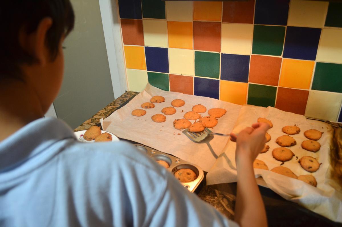 Un niño dispone unas galletas caseras de Navidad en una bandeja en su casa en Miami