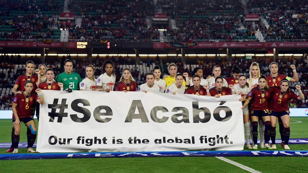 Las jugadoras de España y Suiza, con la pancarta del 'Se acabó'