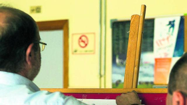 El director del IES León Felipe coloca las notas en el tablón.