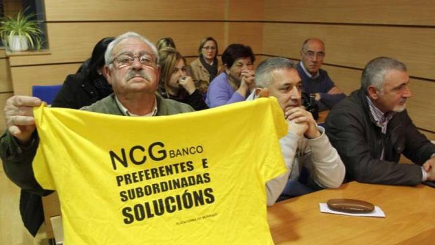 Uno de los afectados muestra una camiseta reivindicativa durante la asamblea de ayer en Moaña.  // C.G.